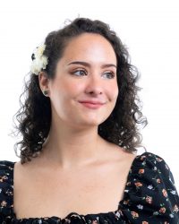 Head-shot of a young woman smiling away from the camera